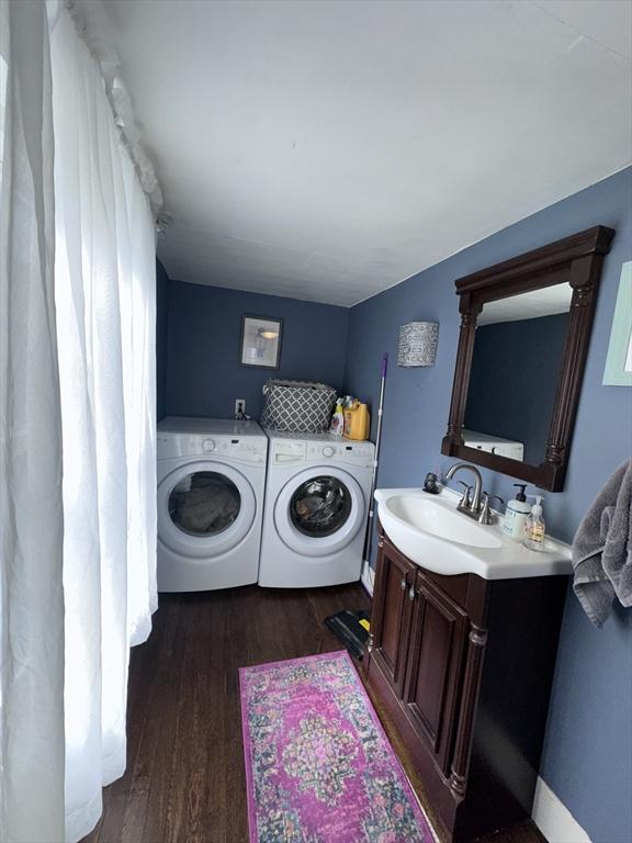 laundry area featuring sink, washer and clothes dryer, and dark hardwood / wood-style floors