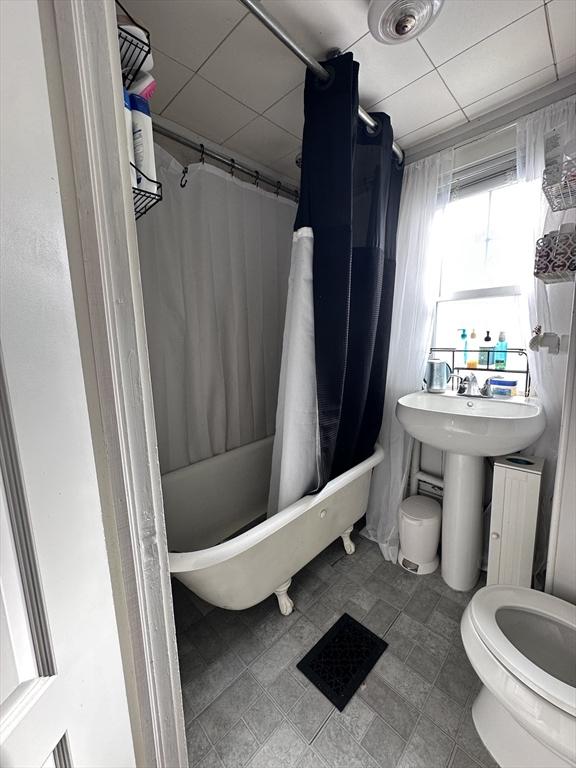 bathroom with toilet and shower / bath combo with shower curtain