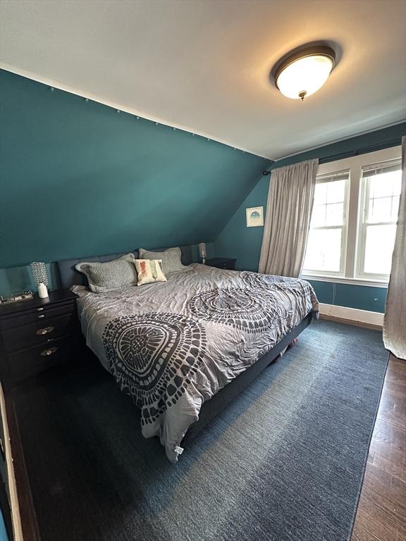 bedroom with dark hardwood / wood-style flooring and vaulted ceiling