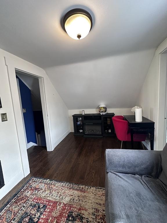 bonus room featuring dark wood-type flooring and vaulted ceiling