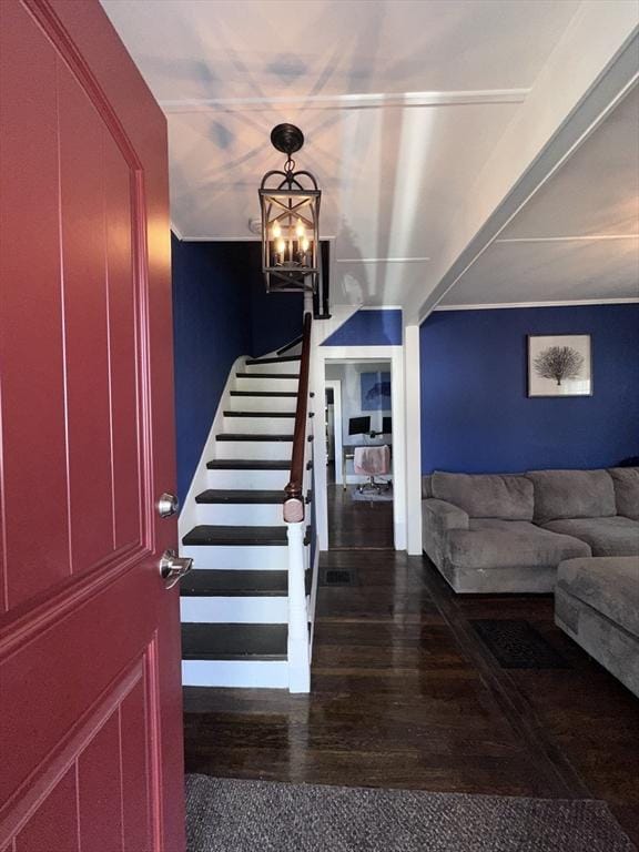 staircase featuring hardwood / wood-style flooring and a chandelier