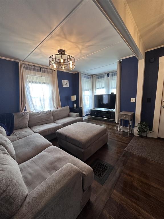 living room with crown molding and wood-type flooring