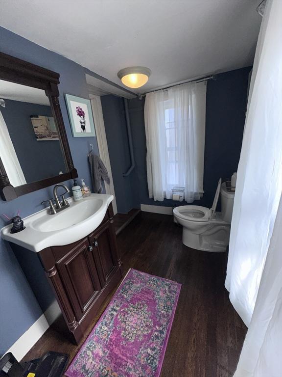 bathroom featuring wood-type flooring, vanity, and toilet