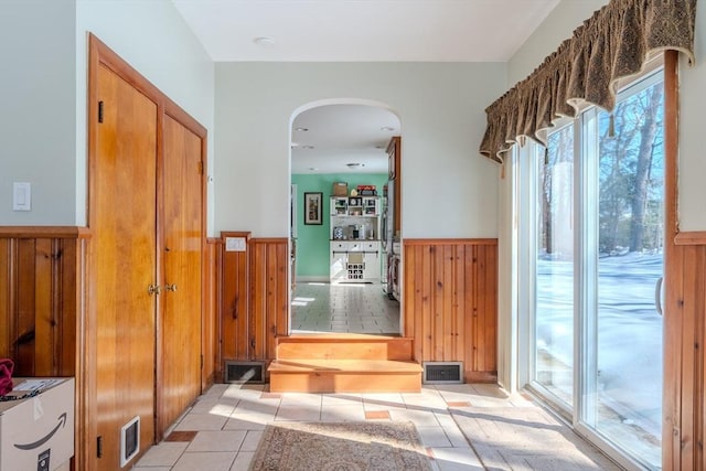 interior space featuring wooden walls and light tile patterned flooring