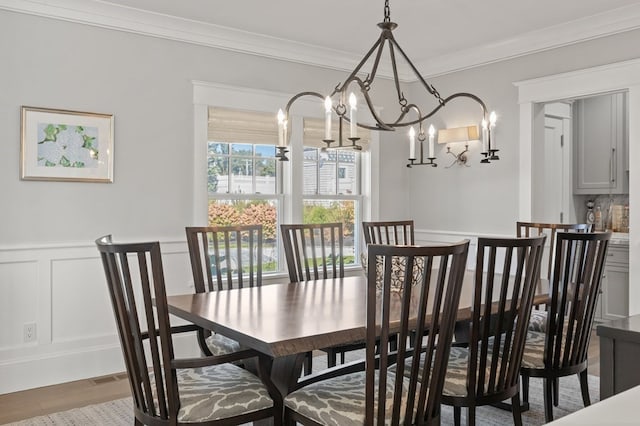 dining space featuring a chandelier, hardwood / wood-style flooring, and crown molding