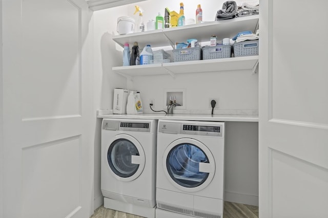 washroom with independent washer and dryer and light hardwood / wood-style floors