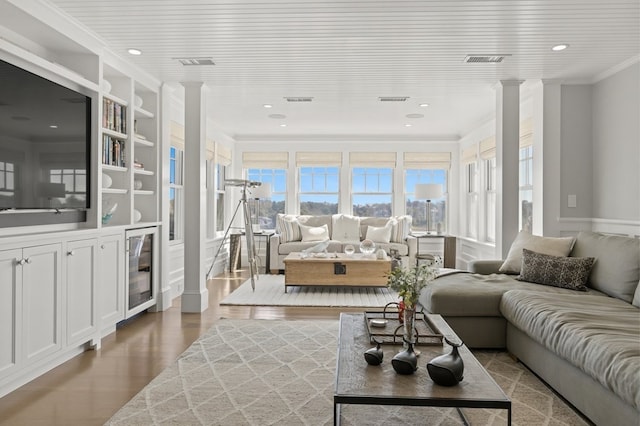 living room featuring hardwood / wood-style floors, ornamental molding, wood ceiling, and decorative columns