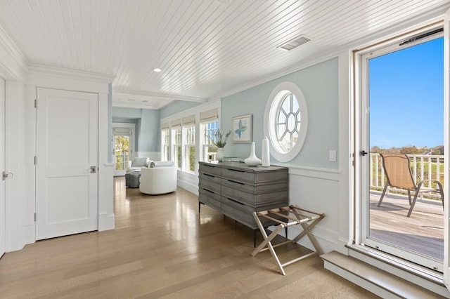 interior space with ornamental molding, light wood-type flooring, and wooden ceiling