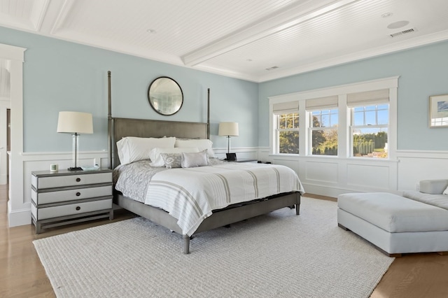 bedroom with beamed ceiling and hardwood / wood-style floors