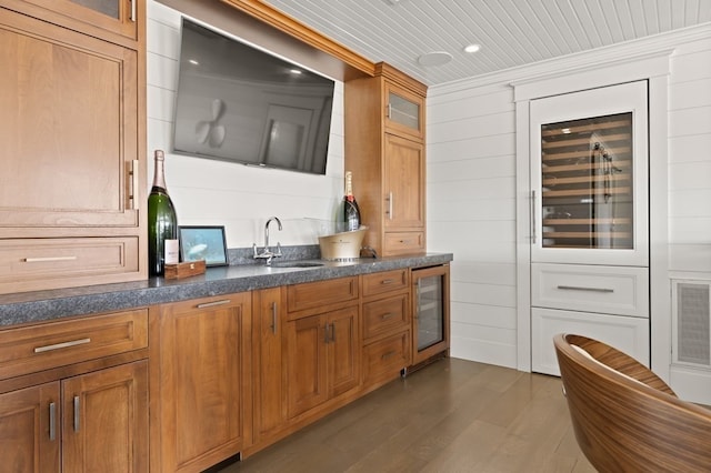 kitchen featuring sink, wine cooler, dark hardwood / wood-style floors, crown molding, and wooden walls