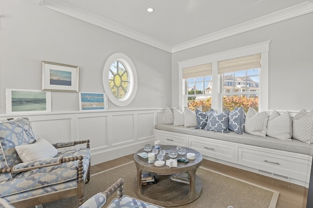 sitting room featuring wood-type flooring and crown molding