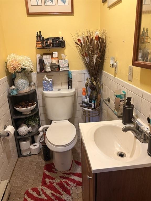 12 Graves Ave, Lynn, MA 01902 - bathroom featuring tile walls, wainscoting, toilet, vanity, and tile patterned flooring