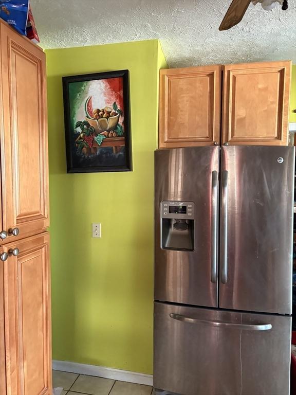 12 Graves Ave, Lynn, MA 01902 - kitchen with stainless steel refrigerator with ice dispenser, light tile patterned floors, ceiling fan, baseboards, and a textured ceiling