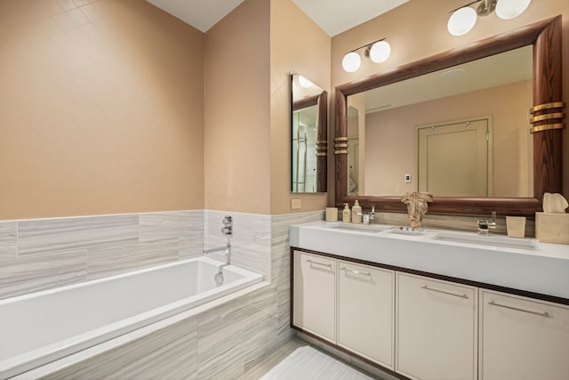 bathroom featuring double vanity and tiled tub