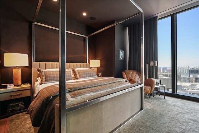 bedroom with carpet flooring and a wall of windows