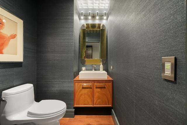 bathroom with vanity, toilet, and hardwood / wood-style flooring