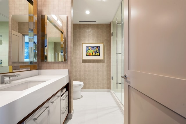 bathroom featuring tile walls, walk in shower, toilet, tile patterned floors, and vanity