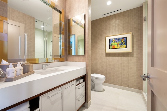 bathroom with vanity, tile patterned floors, toilet, and tile walls