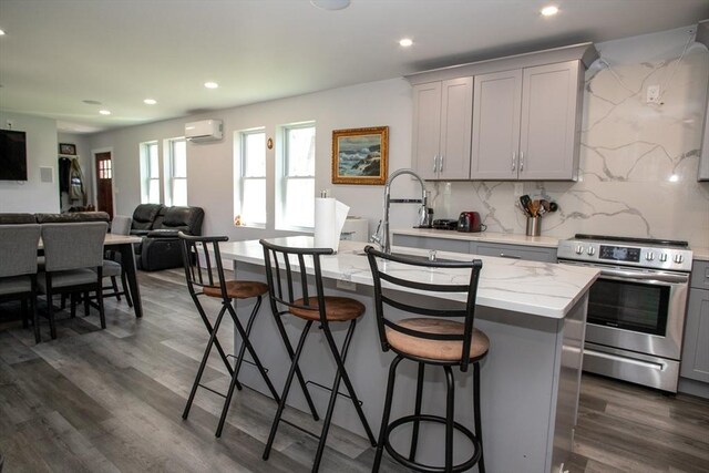 32 Leverett Rd, Shutesbury, MA 01072 - kitchen featuring stainless steel range with electric cooktop, a wall mounted AC, gray cabinets, open floor plan, and dark wood-style flooring