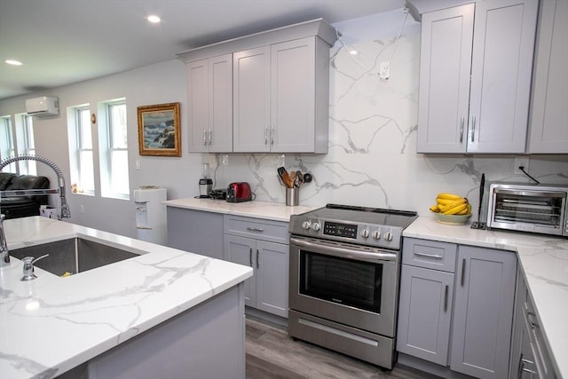 32 Leverett Rd, Shutesbury, MA 01072 - kitchen with electric stove, gray cabinetry, a wall mounted air conditioner, a sink, and backsplash