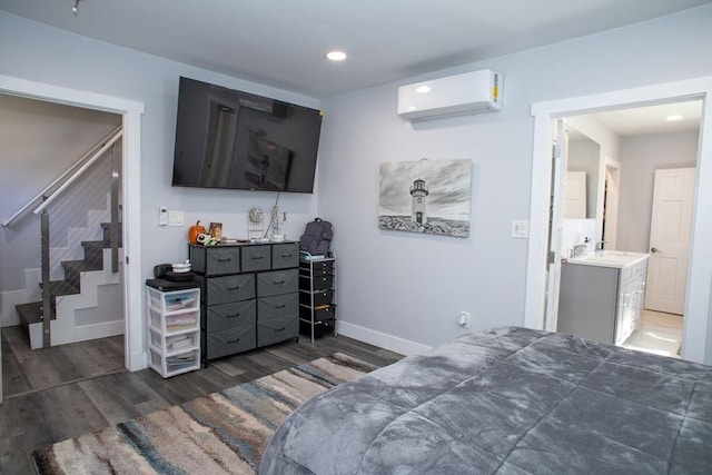 32 Leverett Rd, Shutesbury, MA 01072 - bedroom with a wall unit AC, wood finished floors, baseboards, recessed lighting, and a sink
