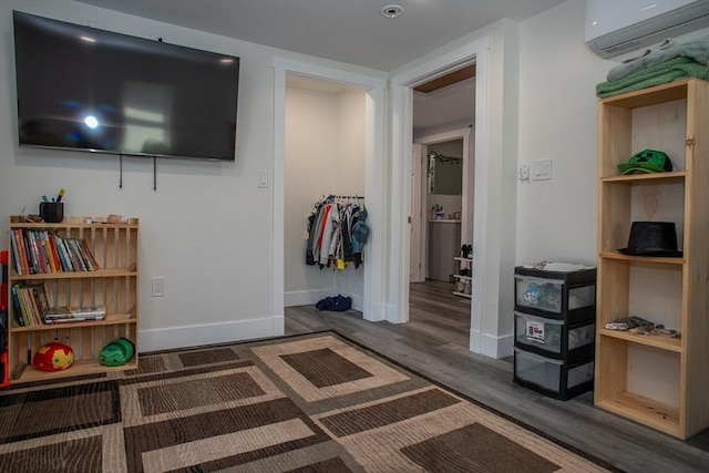 32 Leverett Rd, Shutesbury, MA 01072 - bedroom with a wall unit AC, wood finished floors, and baseboards