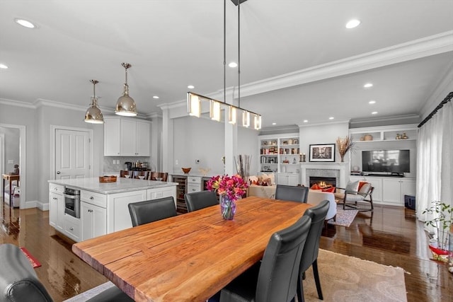 44 Sunset Ridge Ln Unit 44, Bolton, MA 01740 - dining area featuring a warm lit fireplace, dark wood-style flooring, recessed lighting, ornamental molding, and baseboards