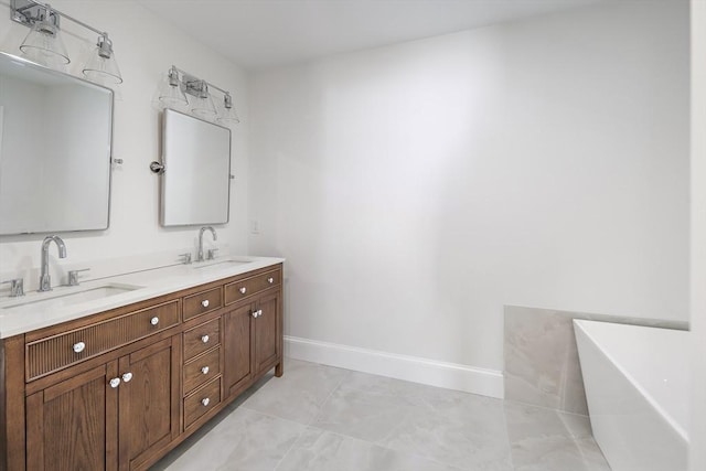 bathroom with double vanity, a soaking tub, baseboards, and a sink