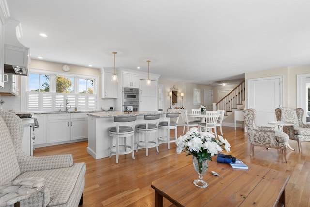 living room featuring sink and light hardwood / wood-style floors