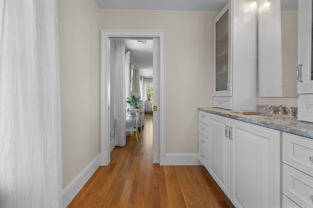 hallway with sink and light wood-type flooring