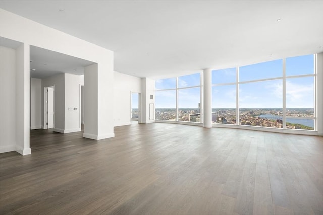 unfurnished living room with dark wood-type flooring and floor to ceiling windows