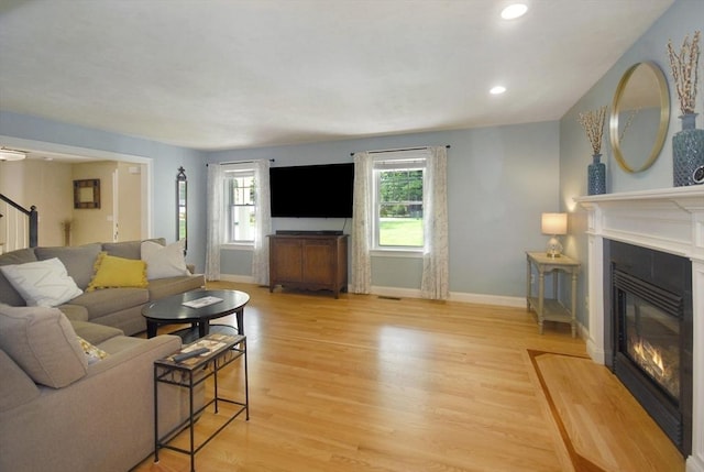 9 Pine Grove Rd, Westford, MA 01886 - living room with light wood finished floors, a glass covered fireplace, recessed lighting, baseboards, and stairway