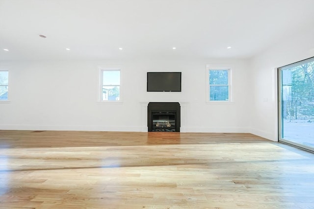 unfurnished living room with light wood-type flooring and a wealth of natural light