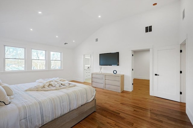 bedroom with high vaulted ceiling and hardwood / wood-style flooring