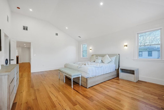 bedroom featuring high vaulted ceiling and light hardwood / wood-style flooring