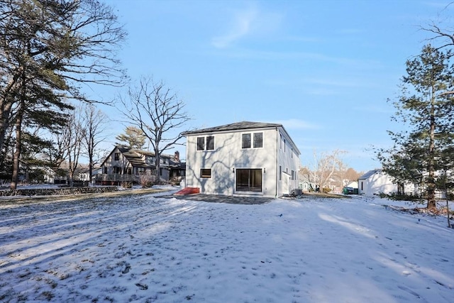 view of snow covered back of property