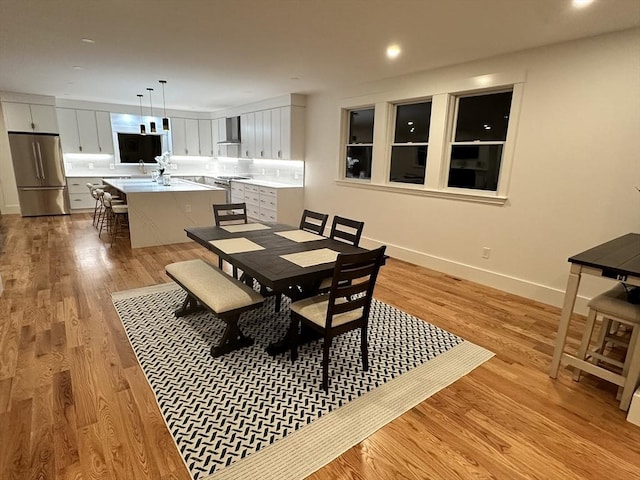 dining area with sink and light hardwood / wood-style floors