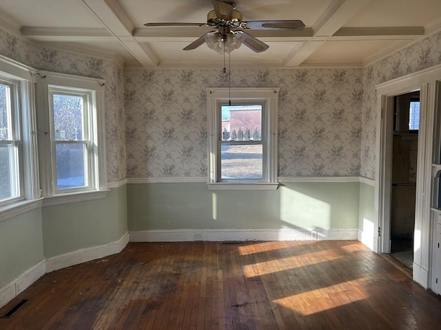 empty room with ceiling fan, dark hardwood / wood-style floors, coffered ceiling, and beamed ceiling