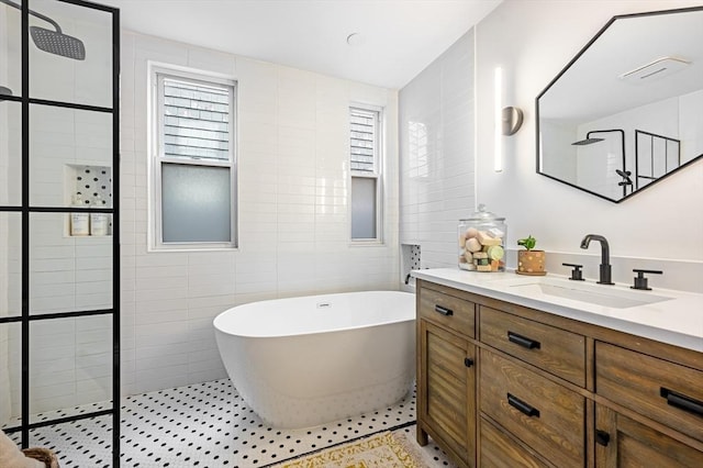 bathroom with vanity, walk in shower, tile walls, and a freestanding bath