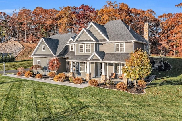 view of front of house featuring covered porch and a front yard