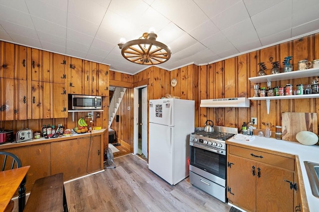 78/80 Curtis Ave, Quincy, MA 02169 - kitchen with stainless steel appliances, under cabinet range hood, brown cabinets, and wooden walls