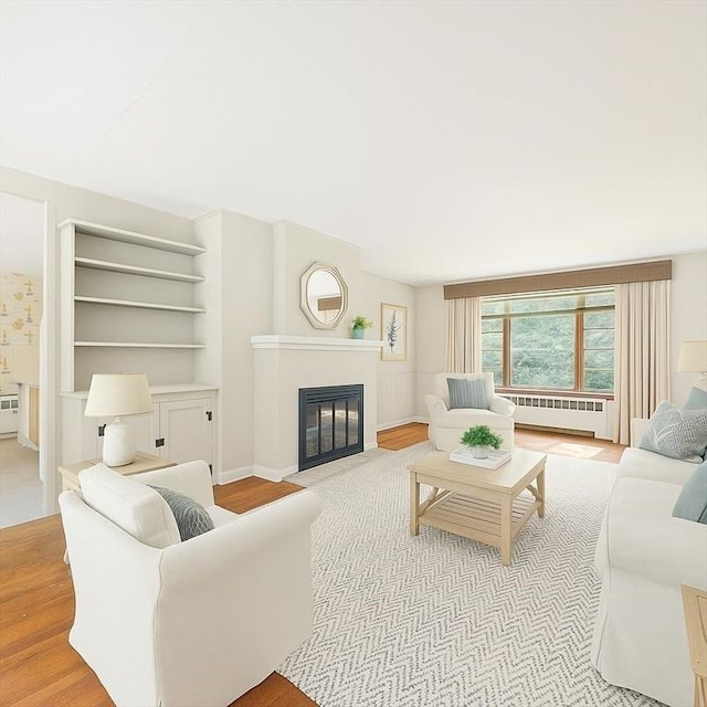 36 Grove St, Hanover, MA 02339 - living area with radiator, a fireplace with flush hearth, and wood finished floors