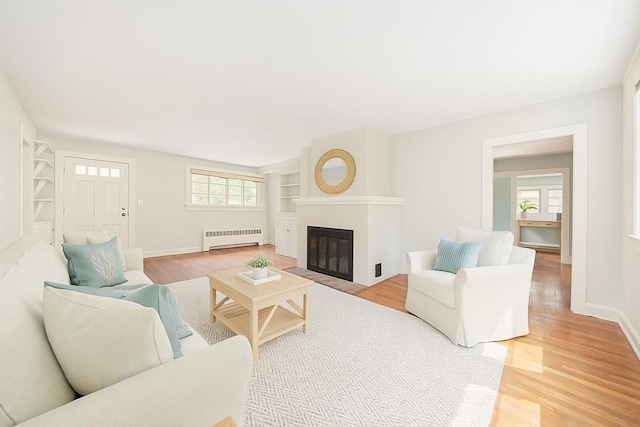 36 Grove St, Hanover, MA 02339 - living room with radiator heating unit, light wood-style flooring, and a fireplace with flush hearth