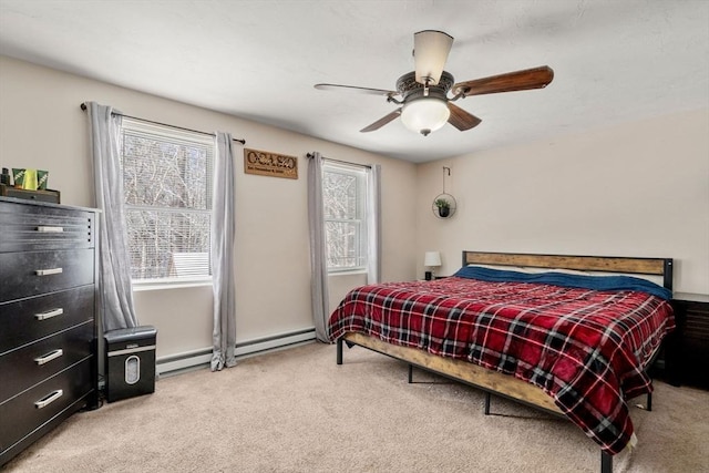 carpeted bedroom featuring ceiling fan and a baseboard heating unit