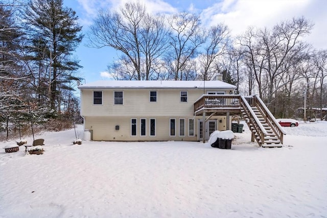 snow covered rear of property featuring a deck