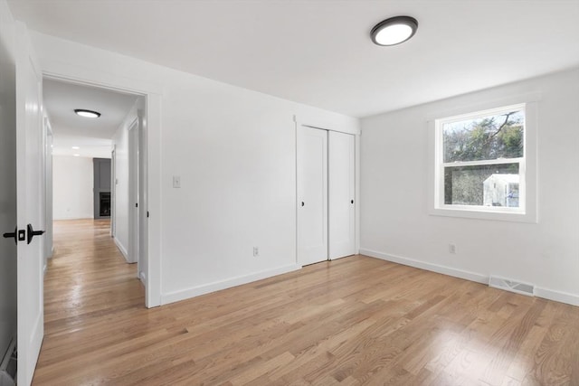 unfurnished bedroom featuring a closet and light hardwood / wood-style flooring