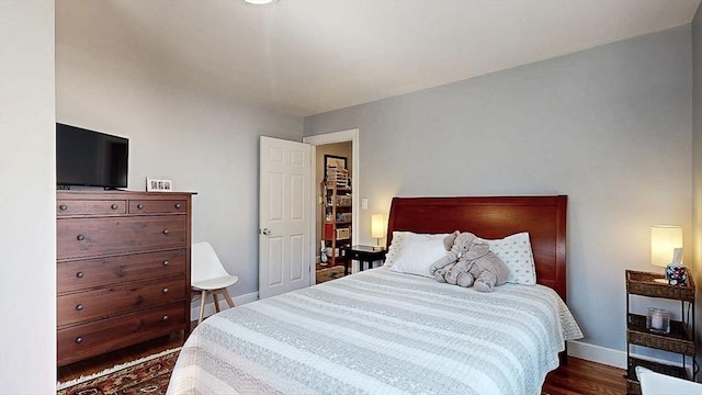 bedroom featuring baseboards and wood finished floors