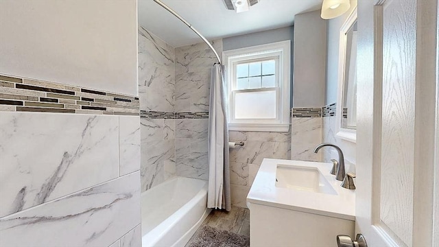 full bath featuring vanity, wood finished floors, shower / bath combo with shower curtain, and tile walls