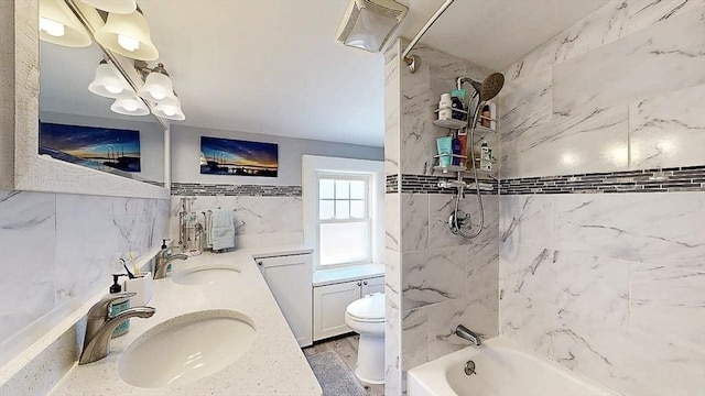 full bathroom featuring double vanity, shower / bathing tub combination, a sink, and toilet