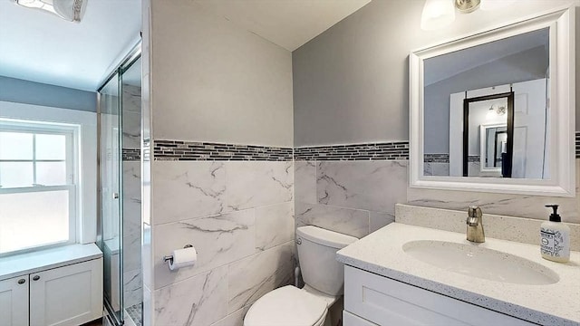 bathroom featuring toilet, tile walls, and vanity